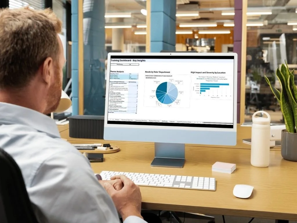 Back view of a man looking at a computer screen displaying a snapshot view of his team's skills.