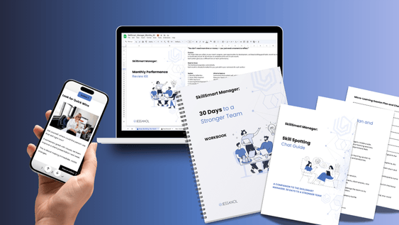 Laptop, phone and various workbooks and printed documents from the SkillSmart Manager course.
