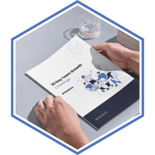 Paper copy of the Manager workbook sitting on a desk, being held by a hand.