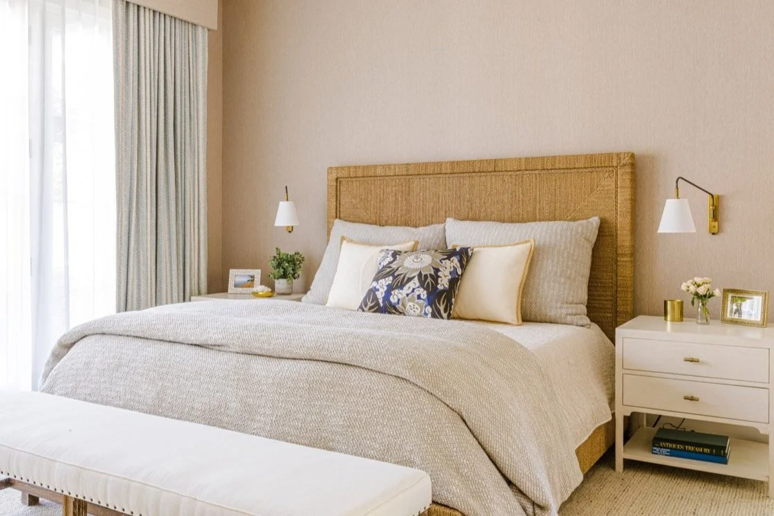 primary bedroom with woven headboard, neutral bedding and white nightstands