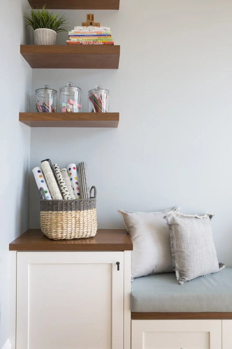 built-in window seat with walnut floating shelves and woven basket