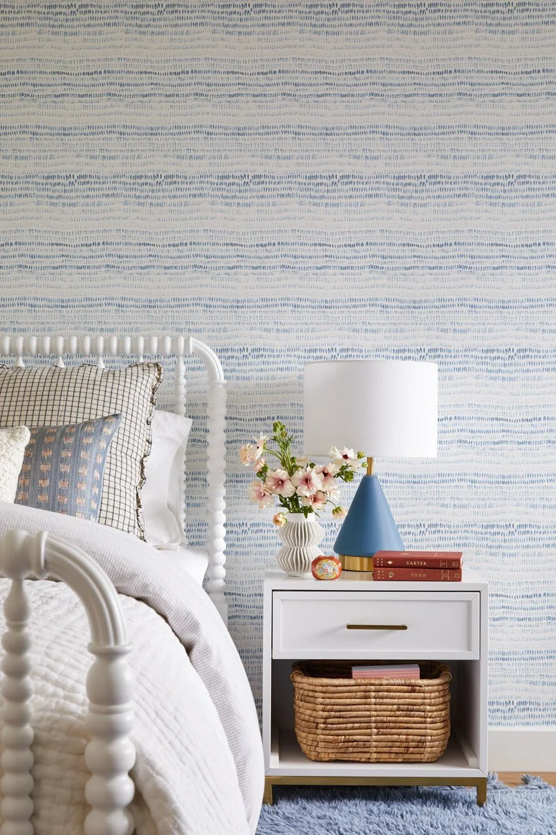 spindle bed beside a white nightstand with woven basket
