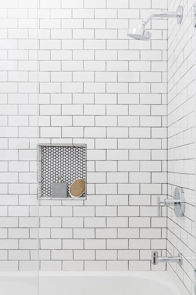 white subway tile shower with patterned tile niche