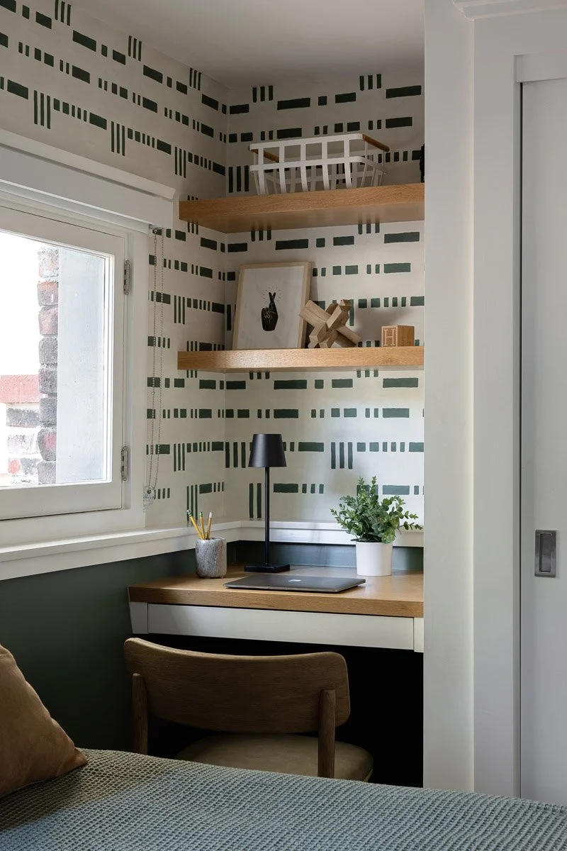 bathroom vanity nook with geometric wallpaper and floating wood shelves