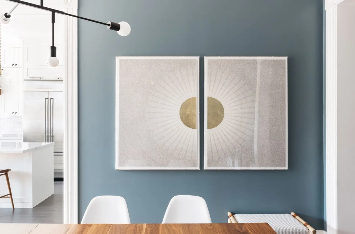 dining room with teal wall, large abstract diptych and white chairs