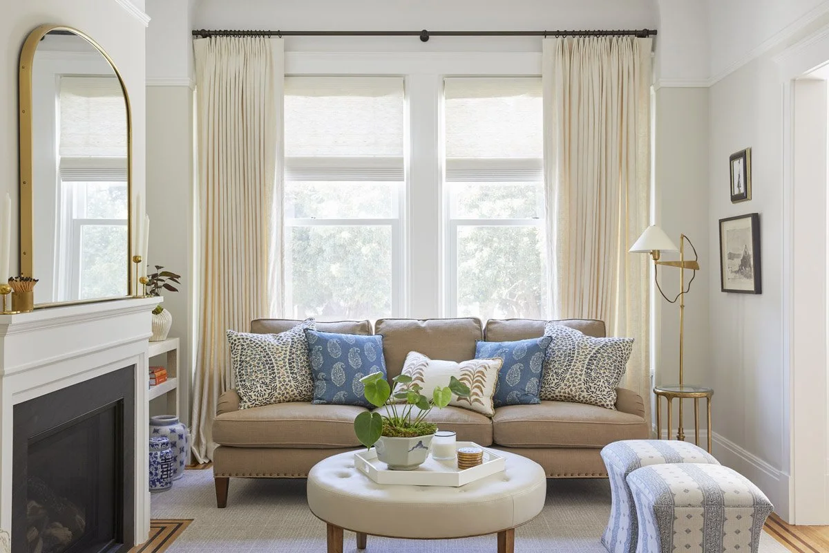 living room with blush sofa, blue pillows and linen curtains