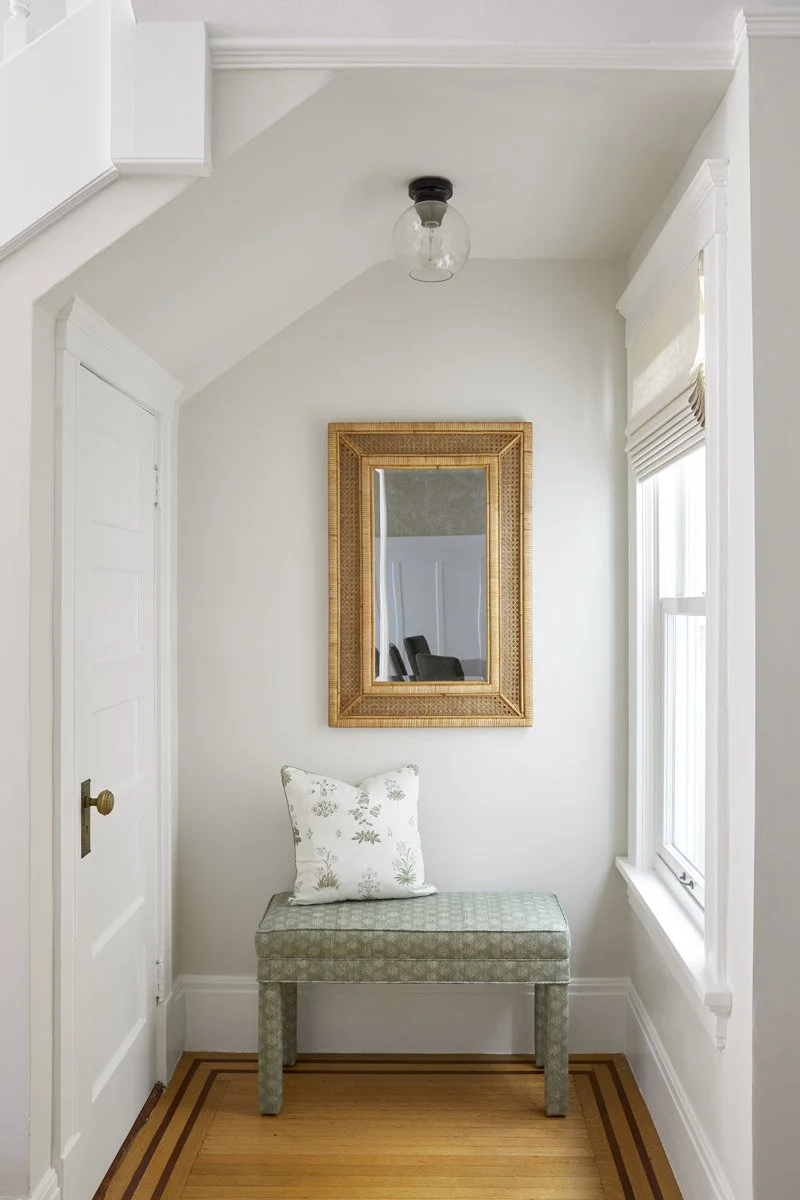 entry hall with brass mirror and upholstered bench