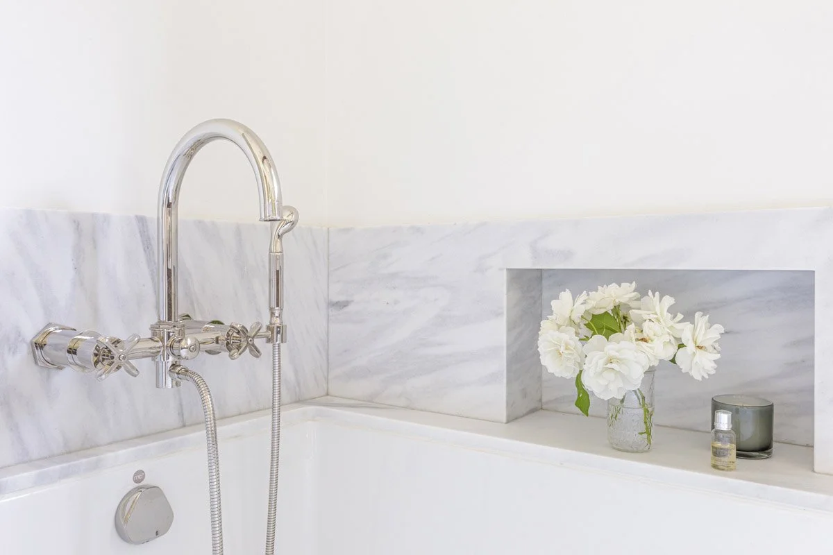 marble tub surround with polished nickel tap and built-in niche