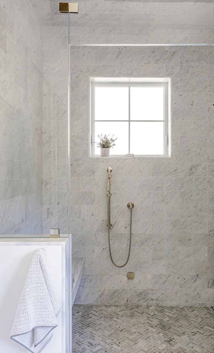 marble walk-in shower with handheld shower and window
