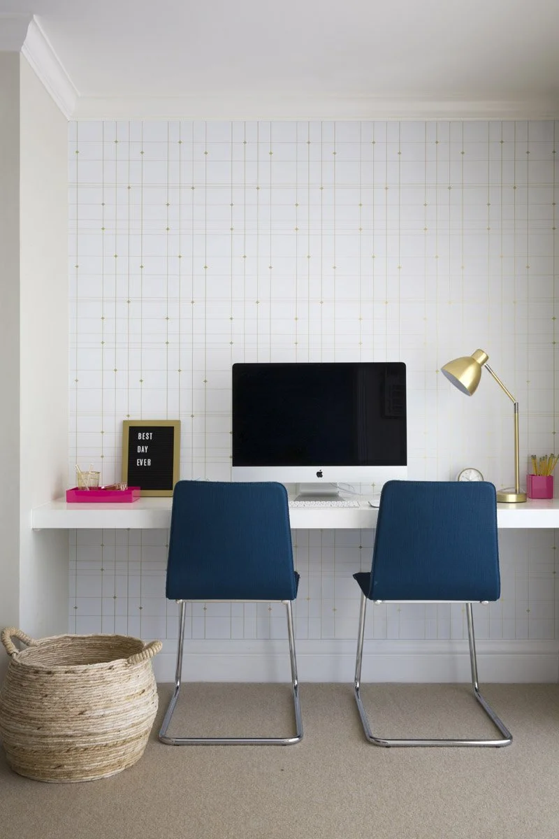 home office with white built-in desk and two navy chairs