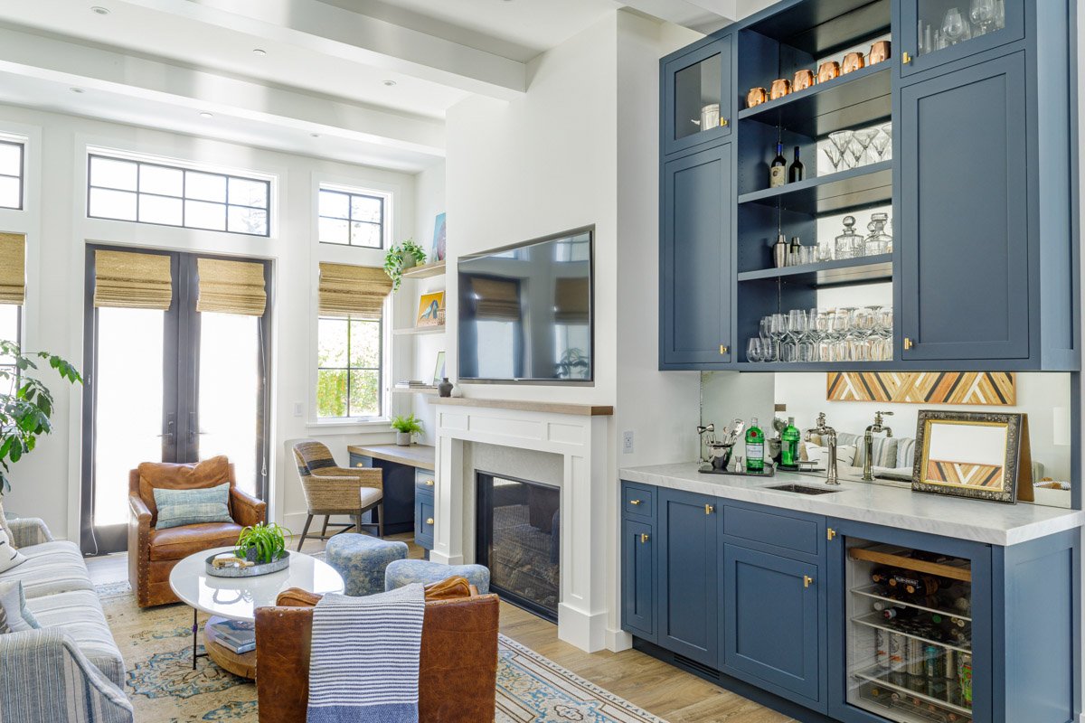 family room with navy built-in bar, fireplace and leather armchairs