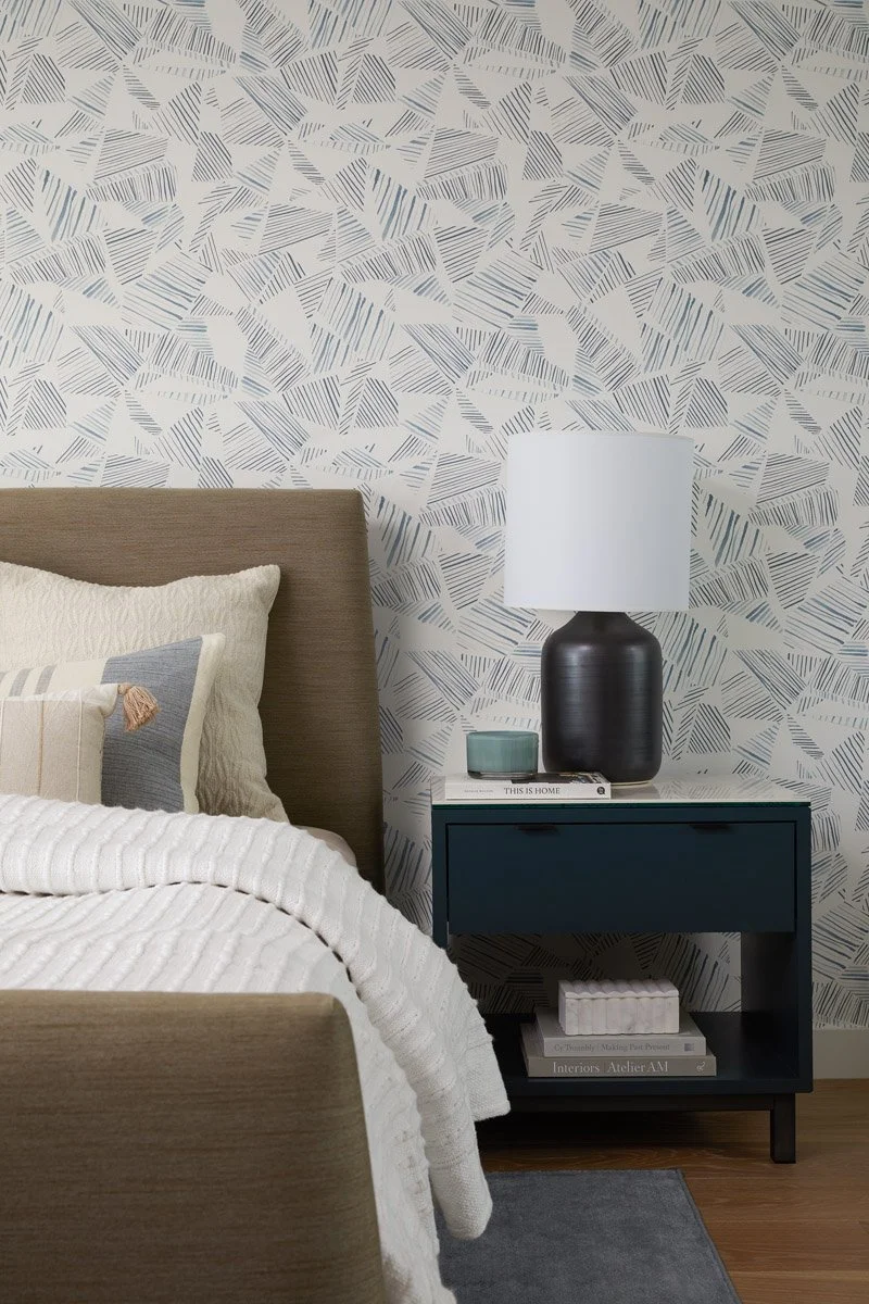 bedside detail with black ceramic lamp and navy nightstand