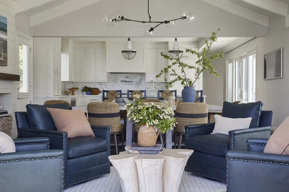 great room with navy seating area and dining table under a vaulted ceiling
