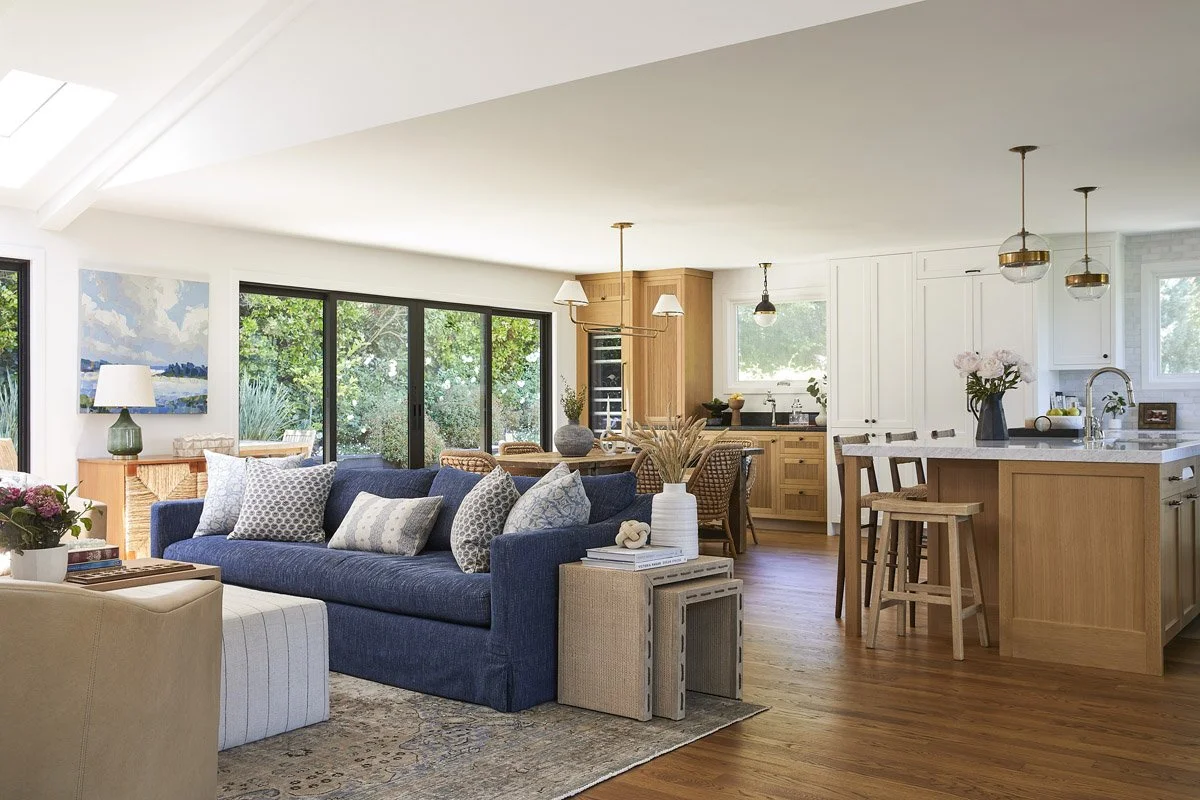 great room with navy sofa flowing into an open kitchen with white oak cabinetry