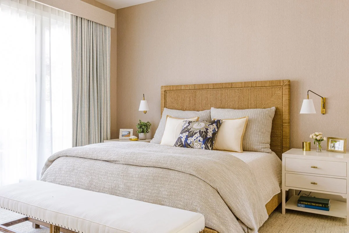 primary bedroom with woven headboard, neutral bedding and white nightstands