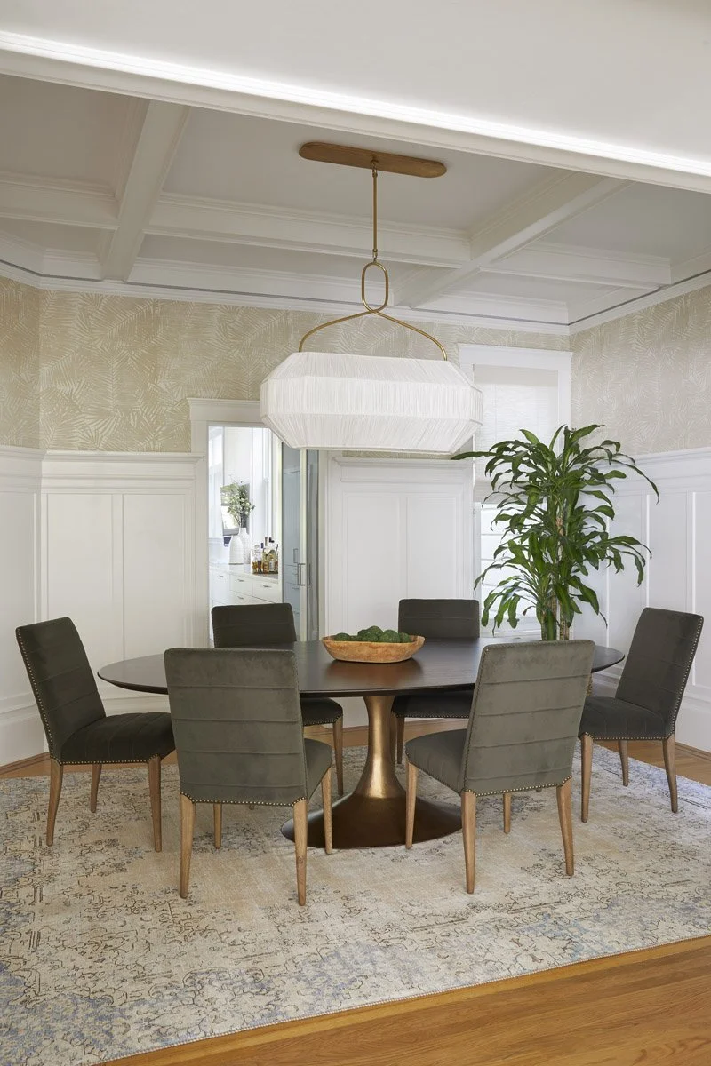 dining room with round wood table, grey upholstered chairs and paper lantern pendant