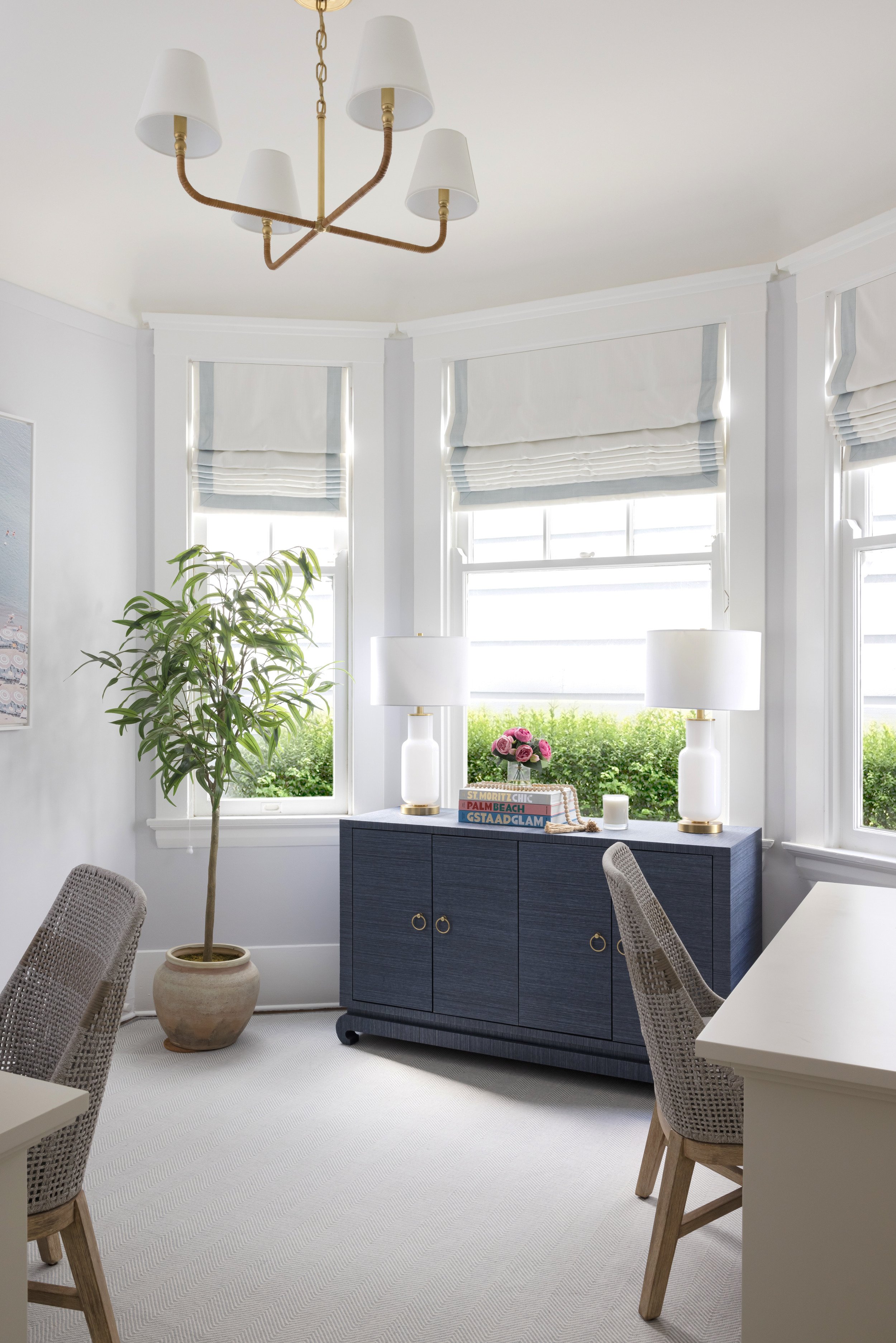 bay window home office with navy cabinetry and brass chandelier