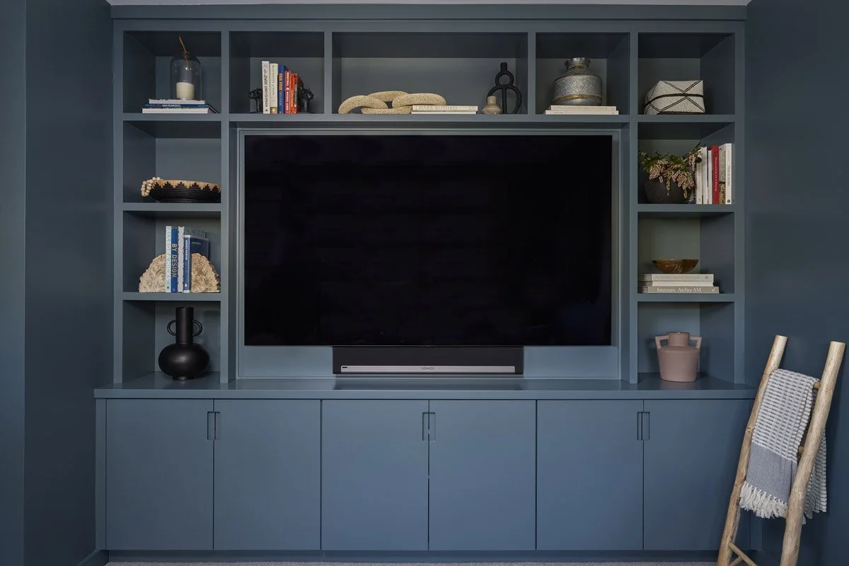 blue built-in media wall with television and open shelving