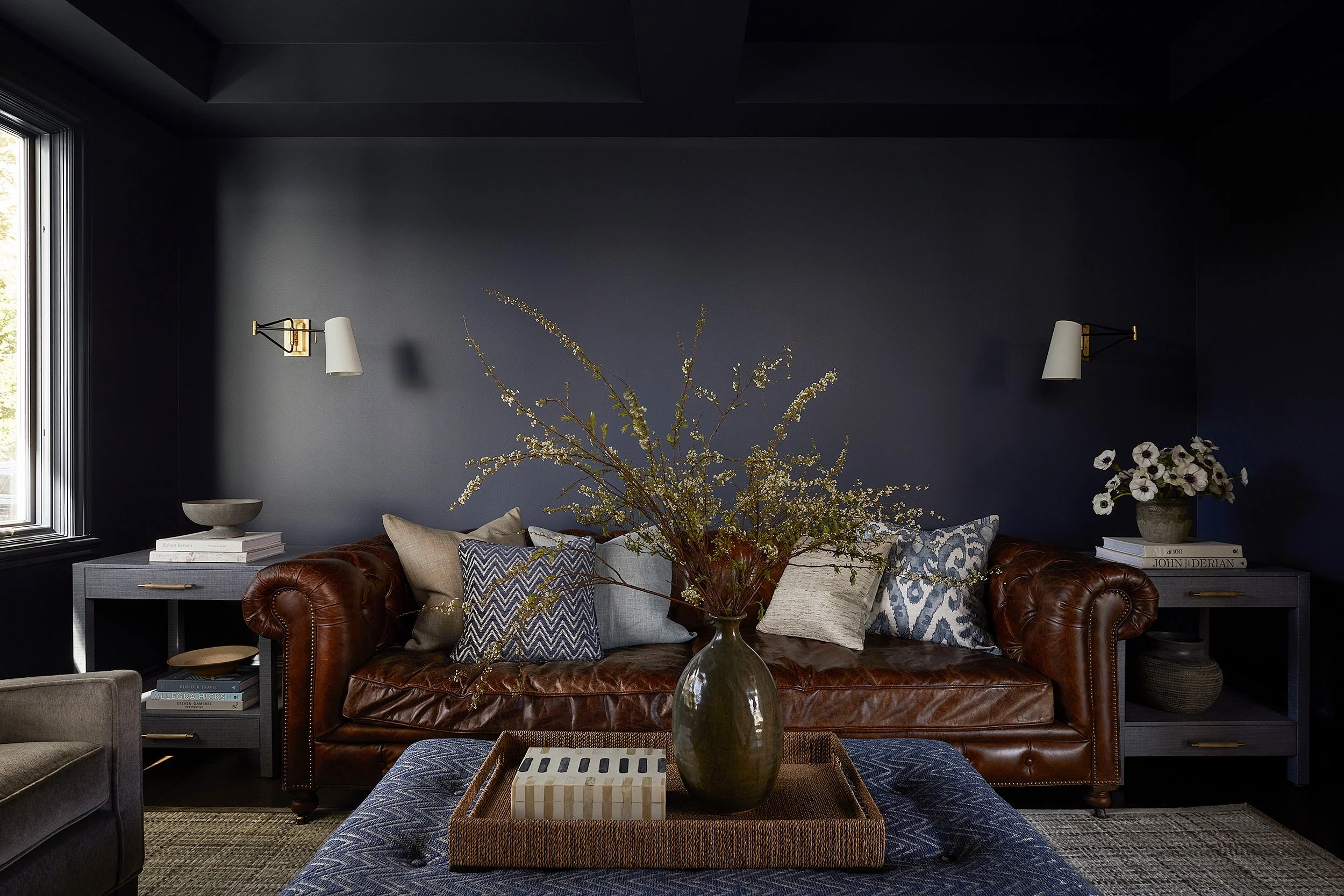 navy den with leather chesterfield sofa and upholstered ottoman