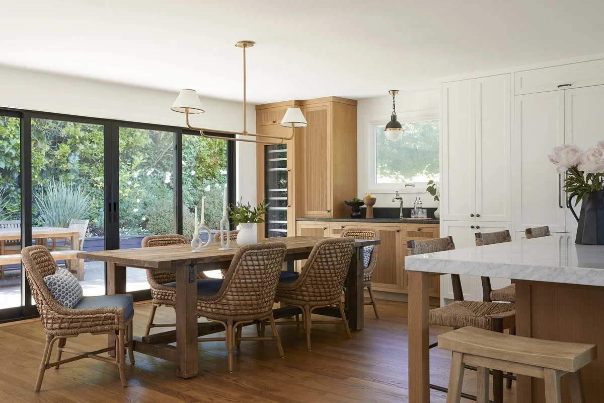 dining area with woven chairs and long wood table beside the kitchen