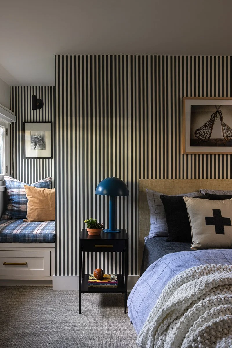 boys bedroom with black and white striped wall and navy bedding