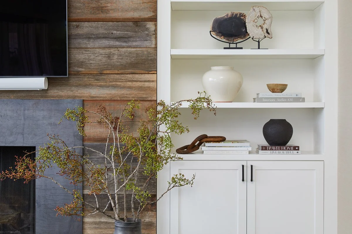 styled built-in shelves next to a reclaimed wood and stone fireplace