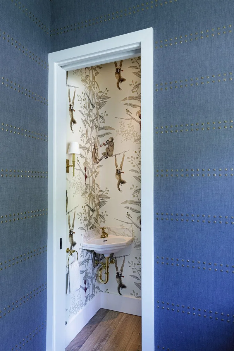 doorway into a powder room with botanical wallpaper