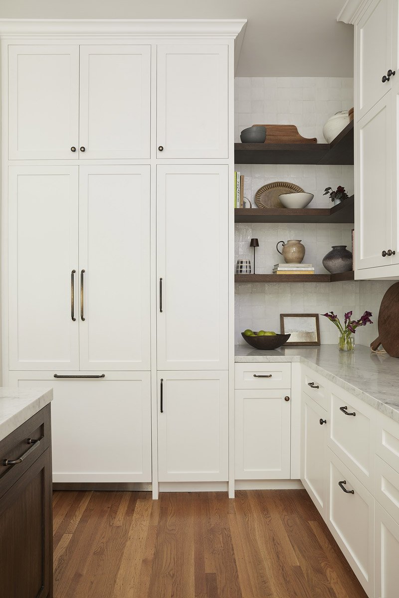 white floor-to-ceiling pantry cabinets with open corner shelving
