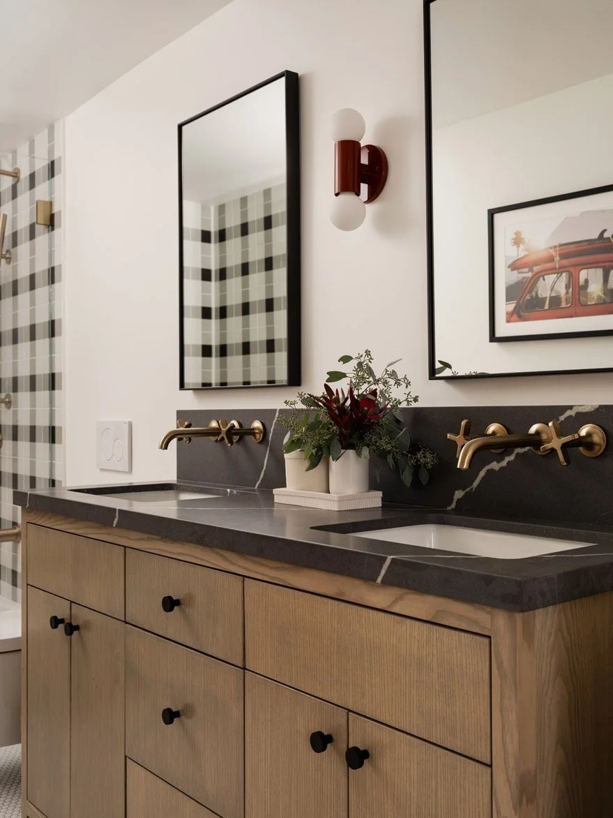 bathroom with white oak vanity, black countertop and brass wall taps