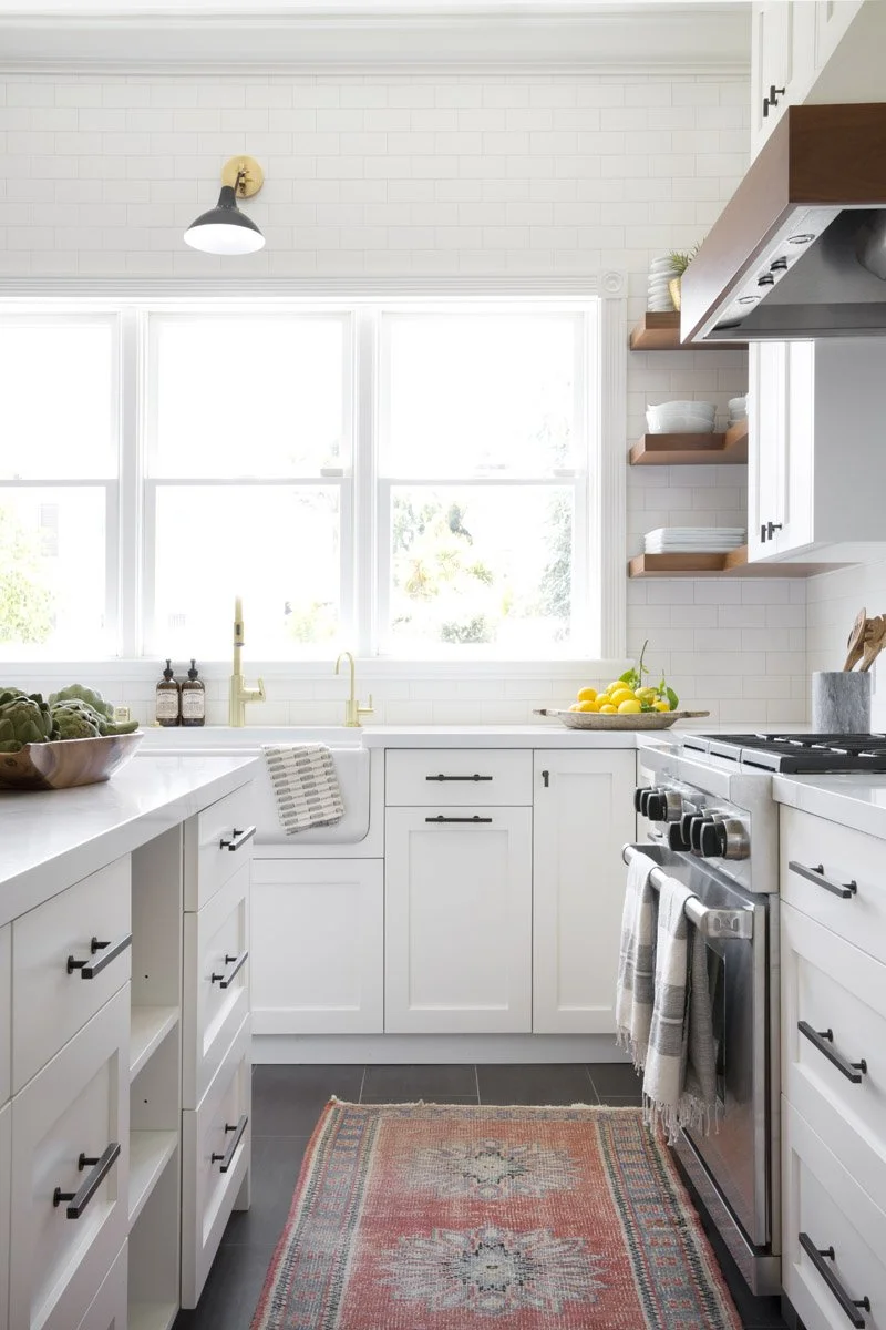 galley kitchen with white cabinetry, range hood and vintage runner