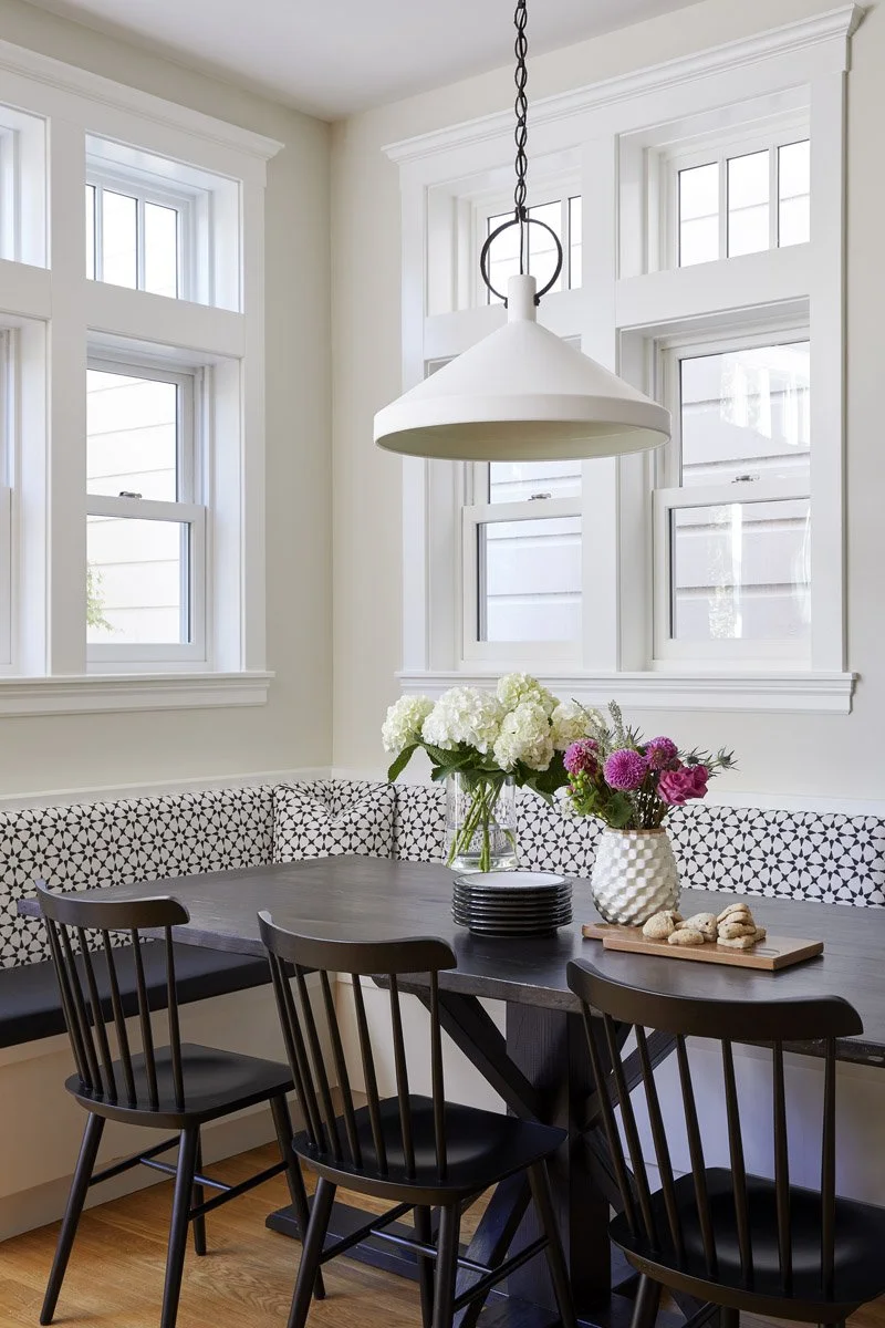 breakfast nook with round black table and patterned banquette