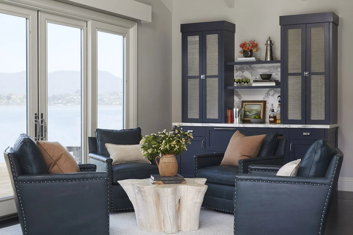 living room with navy leather armchairs, blue sofa and water views