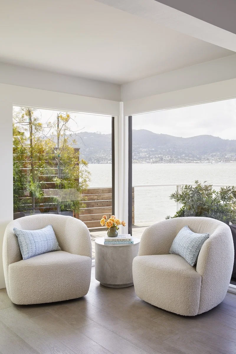 sitting area with two curved armchairs overlooking the water