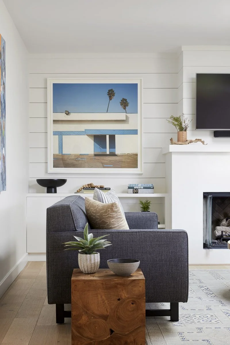 living room with charcoal sofa, white fireplace and modern photography print