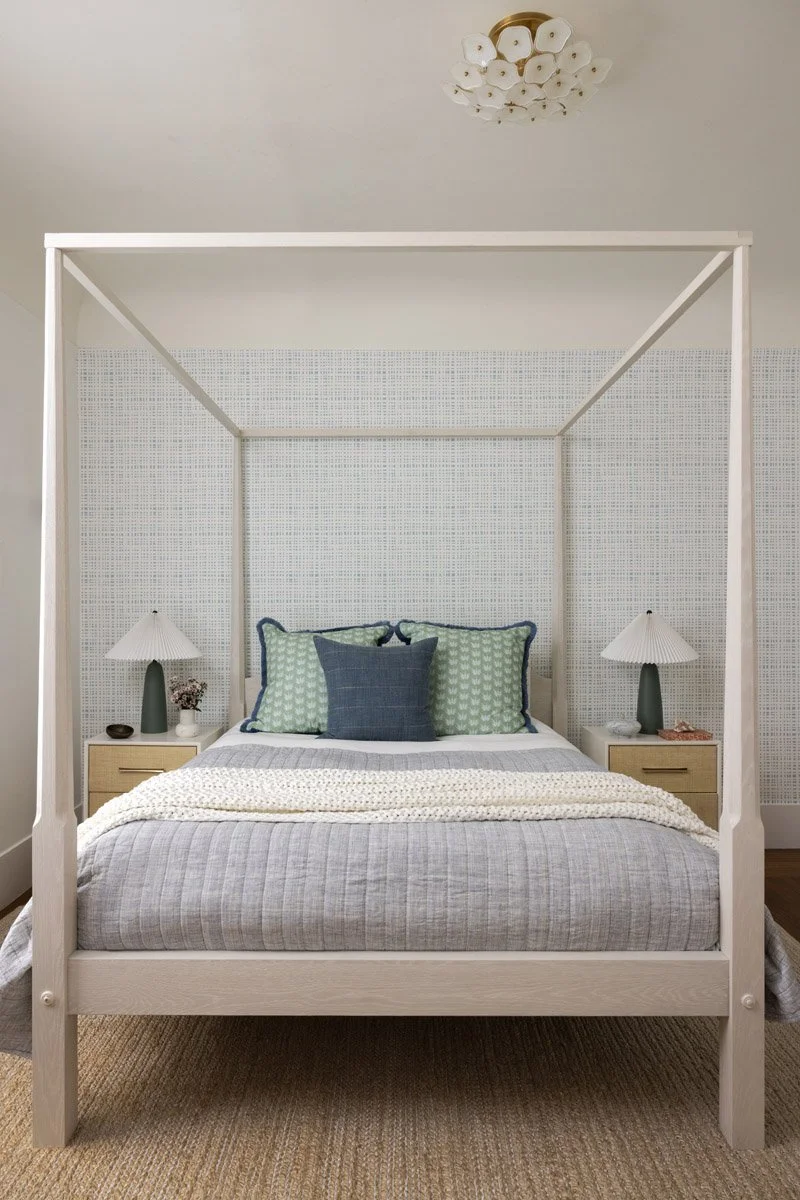 bedroom with white four-poster bed and blue pillows