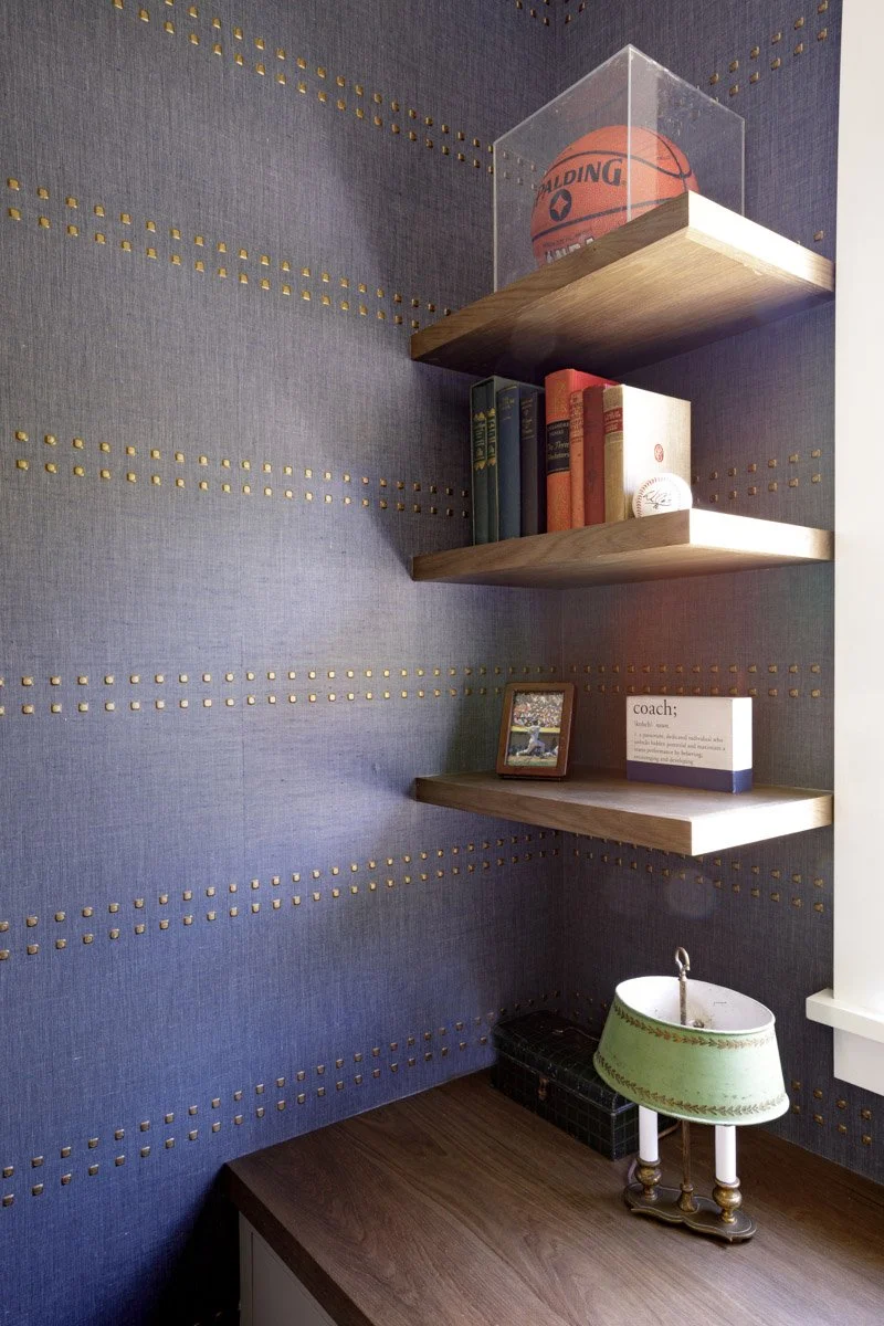 powder room with navy studded walls and floating wood shelves