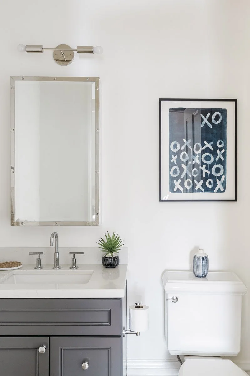 bathroom with grey vanity, framed graphic print and chrome mirror
