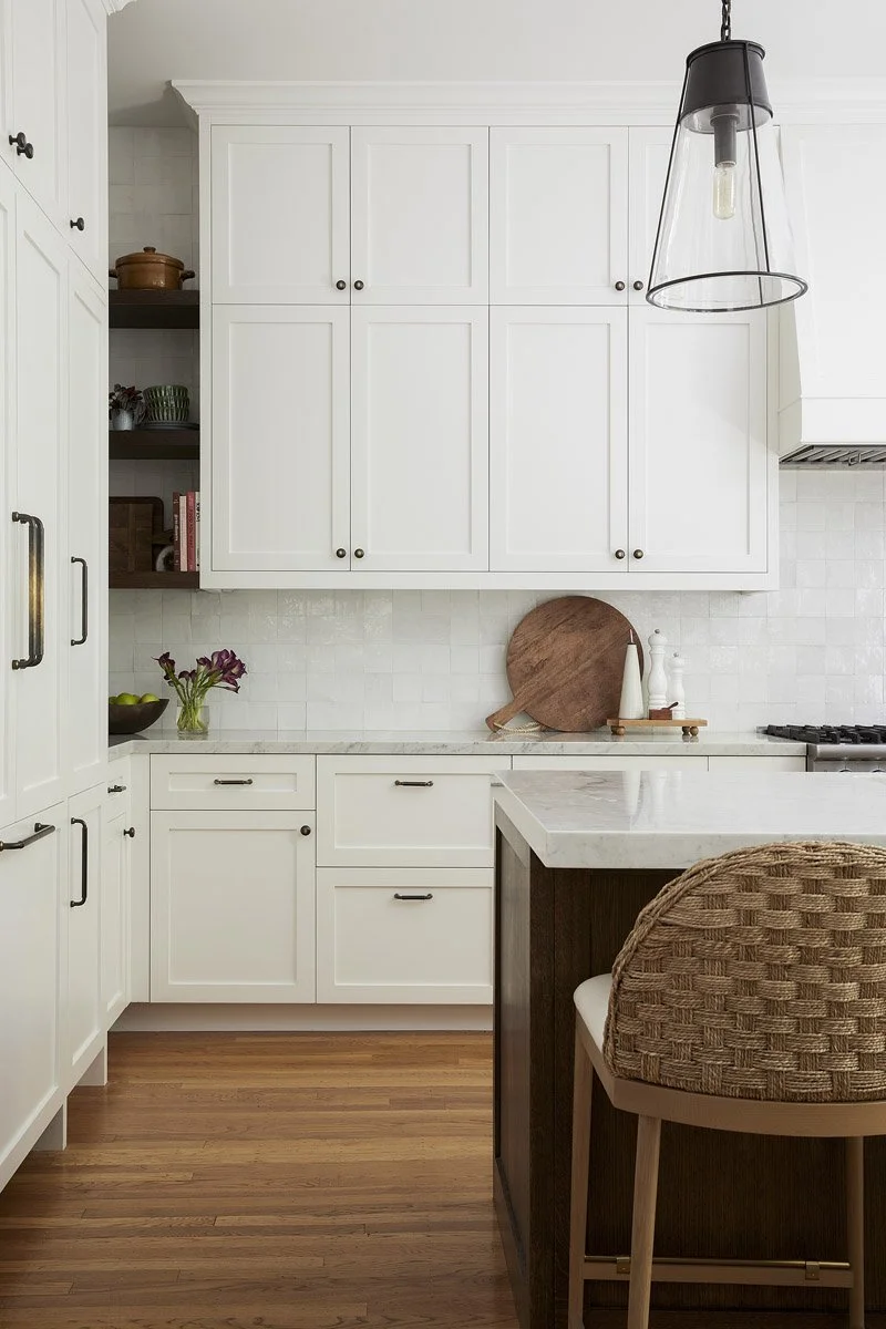white kitchen cabinetry with open shelves and glass pendant light