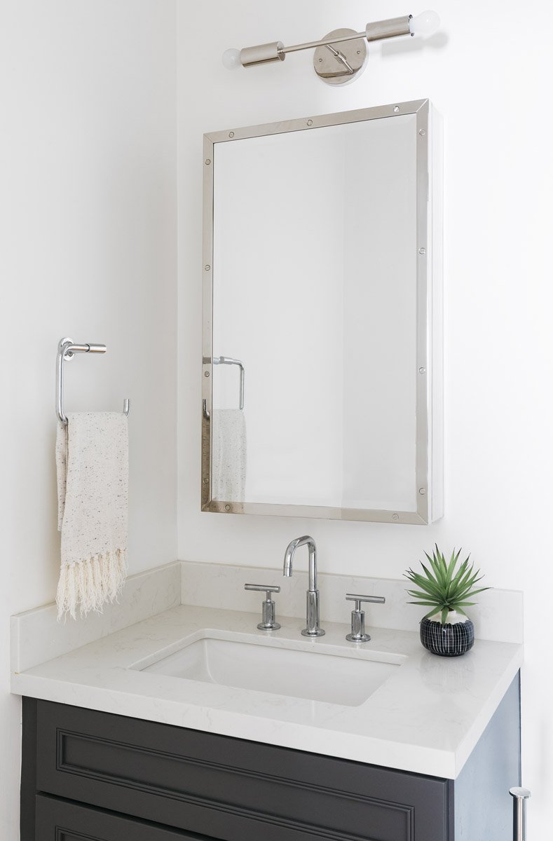 grey vanity with chrome mirror and white countertop