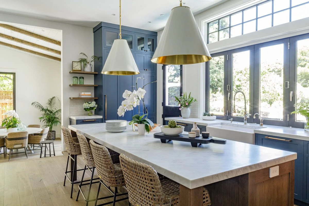kitchen with navy cabinetry, white oak island and oversized white pendants