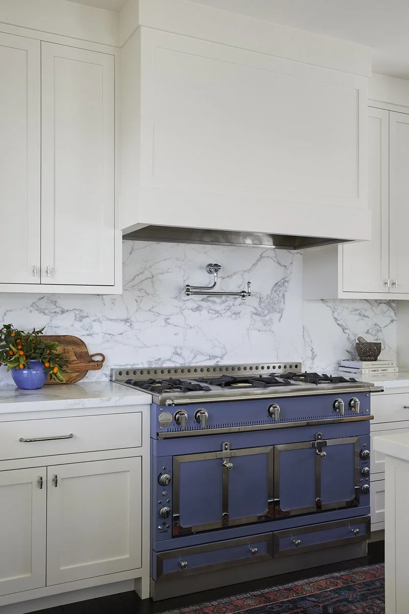 blue range cooker set against a white marble backsplash