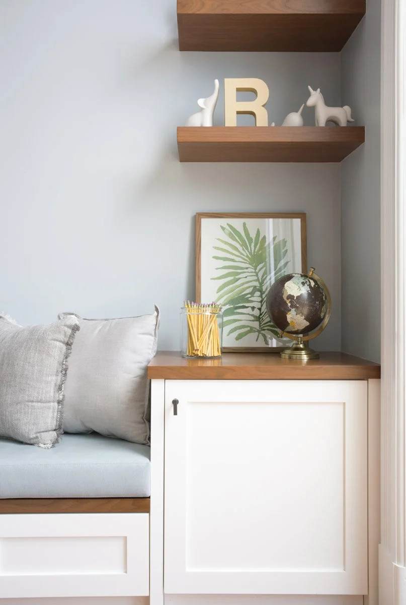 built-in bench nook with floating walnut shelves and framed print
