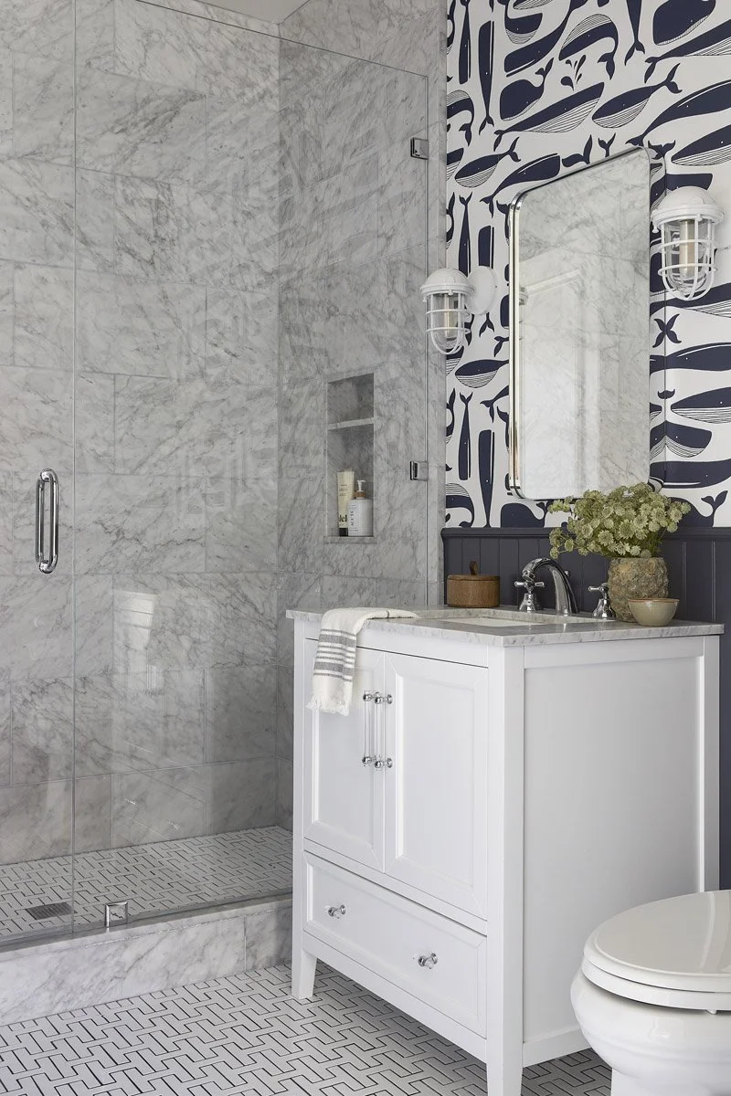 marble bathroom with walk-in shower and whale print wallpaper