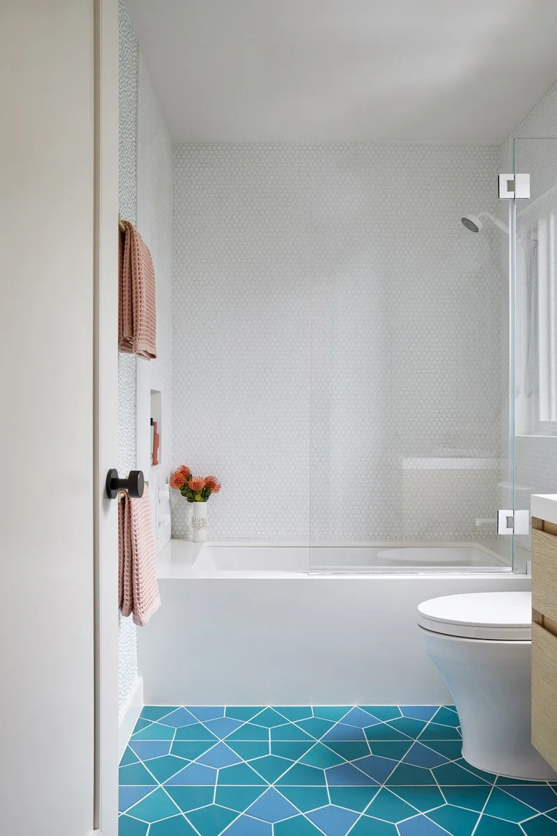 bathroom with shower-tub combination and teal geometric floor tile