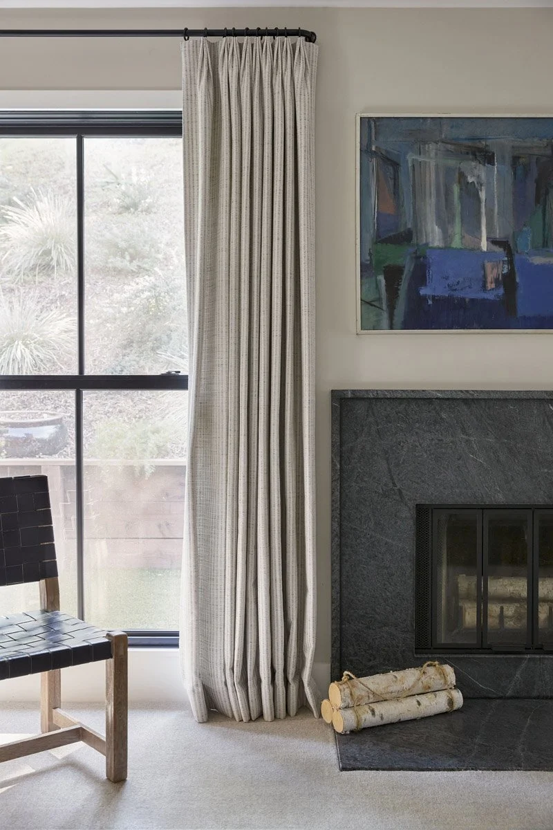 bedroom corner with fireplace, linen curtains and wooden chair