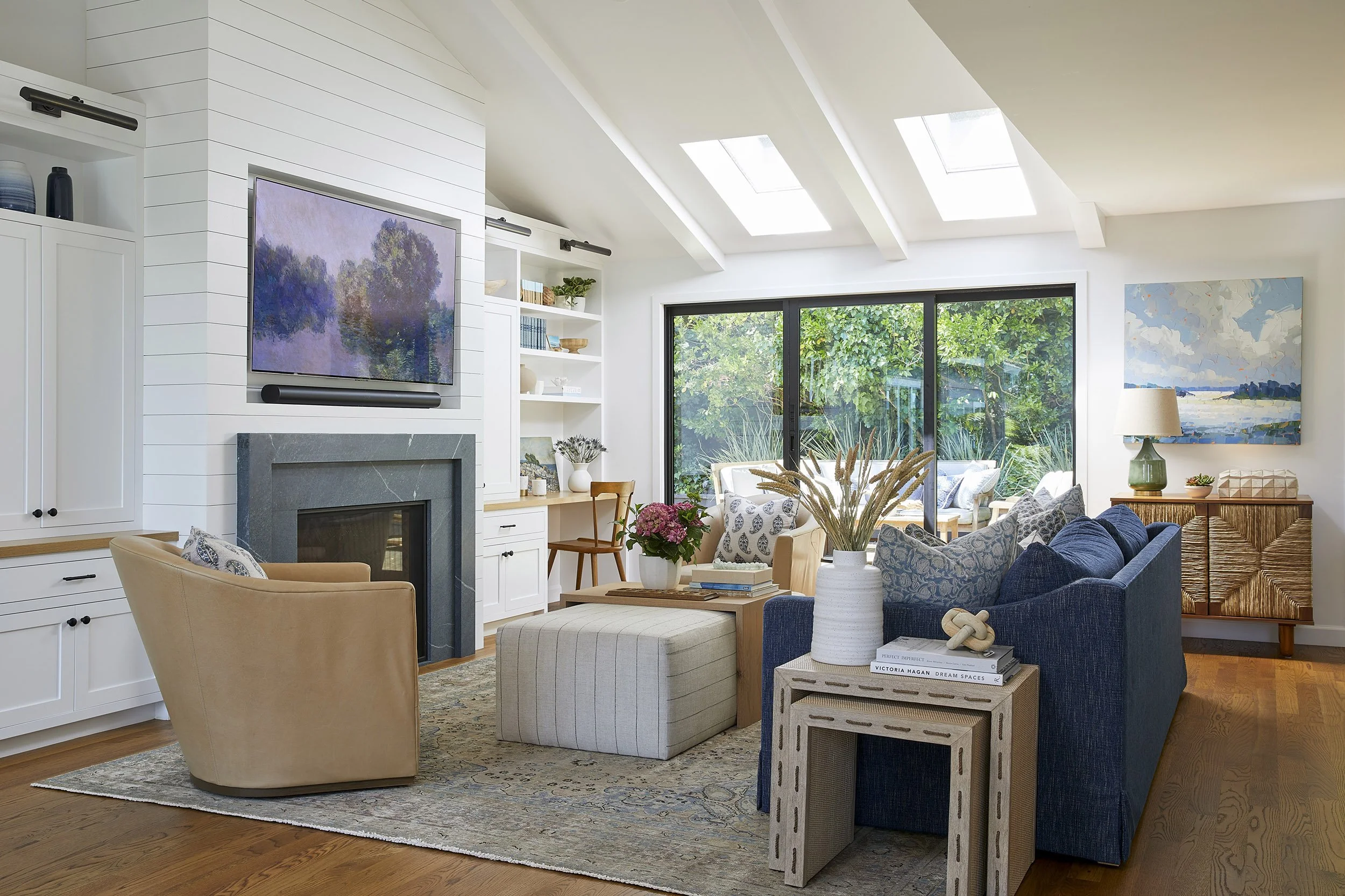 living room with fireplace, swivel chairs, navy sofa and skylights