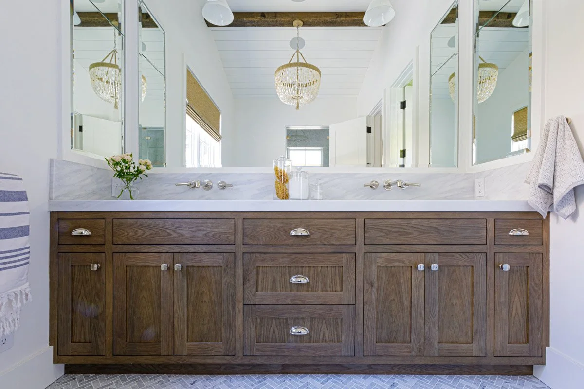 primary bathroom with dark wood double vanity and chandelier