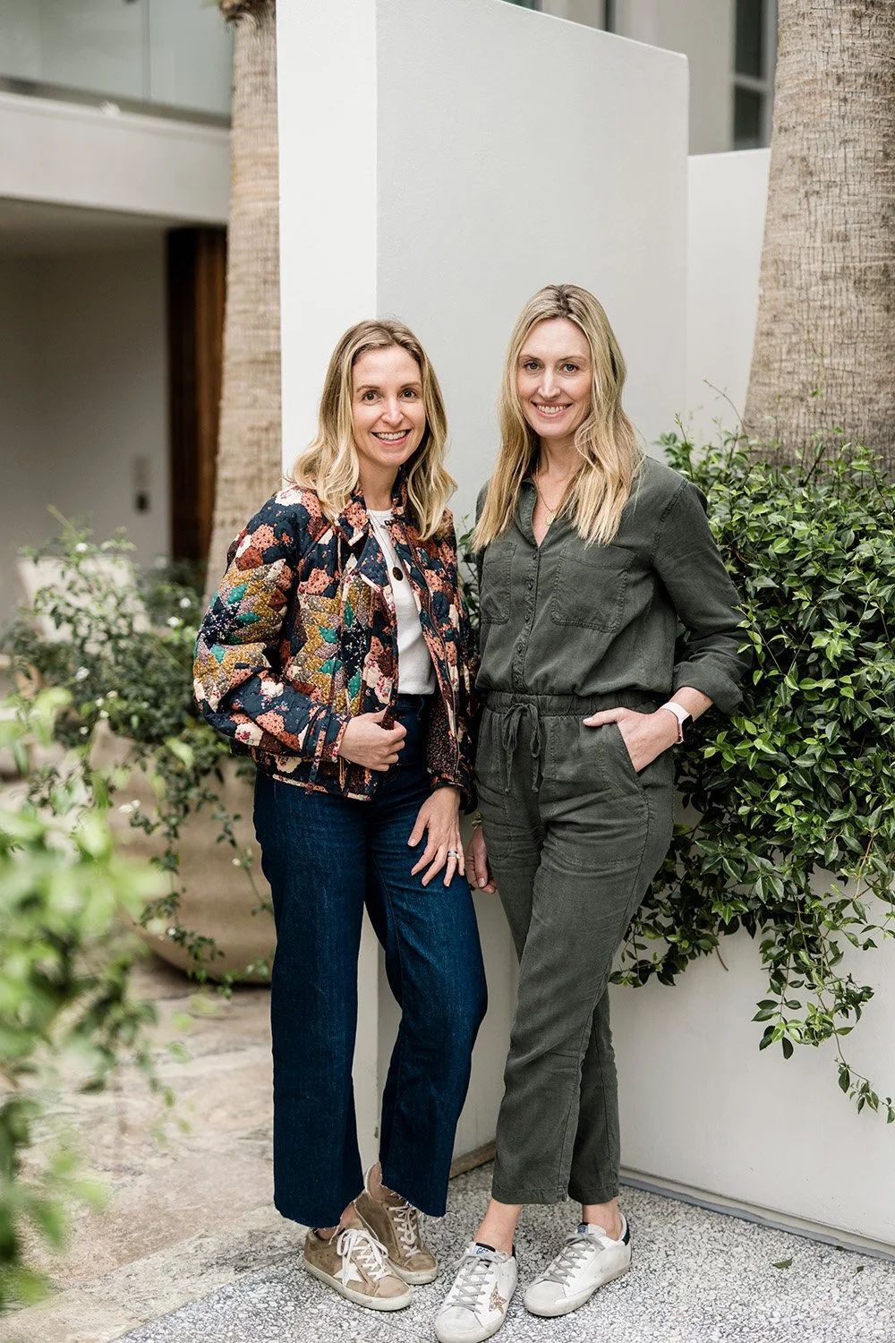 Sidemark Studio founders Ushi and Zoe standing in front of greenery
