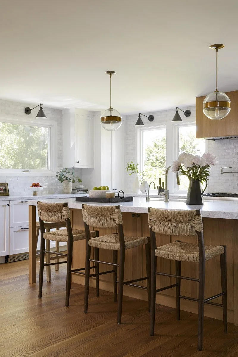 kitchen island with rush seat counter stools and globe pendant lights