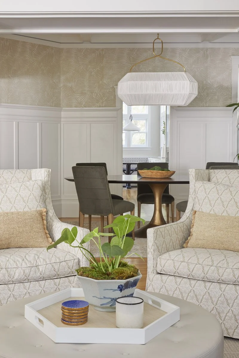pair of slipcovered armchairs looking into a dining room